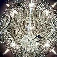 Photomultipliers line the steel chamber of the Borexino detector in this image taken during the detector's construction phase. While the chamber is spherical, the appearance is exaggerated by the distortion of the view through the camera lens.<br /><br />Credit: Virginia Tech; INFN